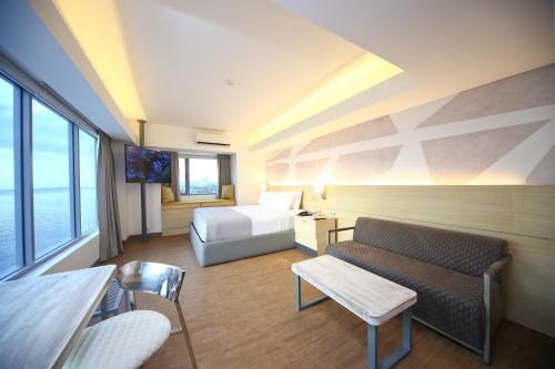 a hotel room with a bed and a couch at TRYP by Wyndham Mall of Asia Manila in Manila