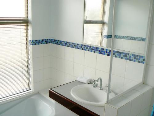 a white bathroom with a sink and a tub at Geraldton Luxury Retreat 2 with free Streaming in Geraldton