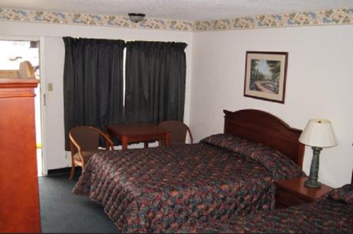 Habitación de hotel con 2 camas, mesa y escritorio en Budget Inn, en Waco