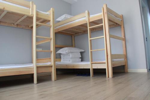 two bunk beds in a room with wooden floors at Lemongo Youth Hostel Hohhot in Hohhot