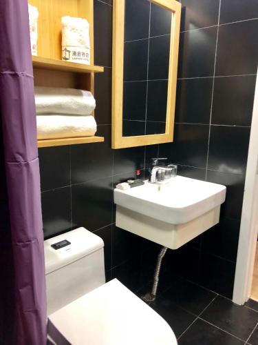 a bathroom with a sink and a toilet and a mirror at Lemongo Youth Hostel Hohhot in Hohhot
