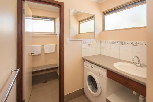 a laundry room with a washing machine and a sink at Siesta Park Holiday Resort ABSOLUTE BEACHFRONT RESORT in Busselton