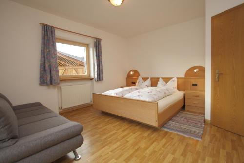 - une chambre avec un lit, un canapé et une fenêtre dans l'établissement Paderlafoderhof, à Laion