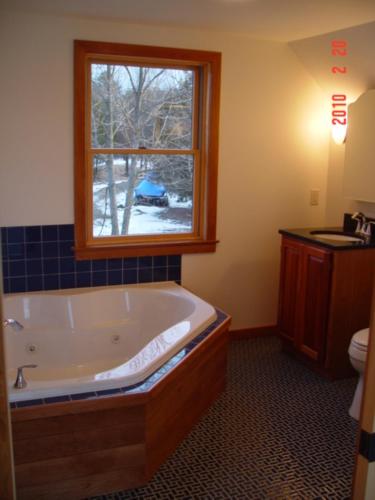 baño con bañera y ventana en Breathtaking New Premier Lake Champlain Waterfront Escape!, en Addison