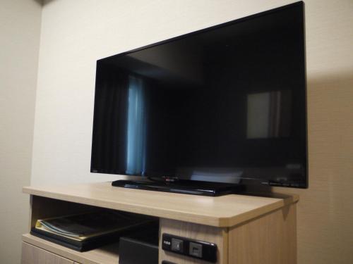 a flat screen tv sitting on top of a cabinet at Hotel Route-Inn Kisarazu in Kisarazu