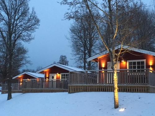 a house in the snow with lights on it at Eksjö Camping & Konferens in Eksjö
