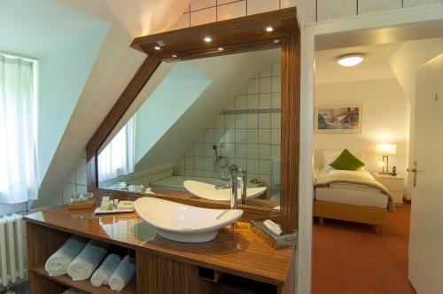a bathroom with a large mirror and a sink at Hotel Allegro in Cologne