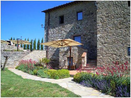 a stone building with an umbrella in front of it at Casalta Di Pesa in Siena