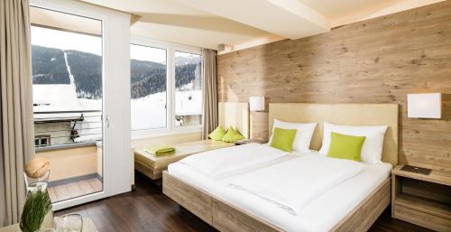 um quarto com uma cama grande e uma janela em Aktiv Hotel Edelweiss em Resia