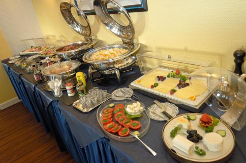 a buffet with many different types of food on a table at Hotel Allegro in Cologne
