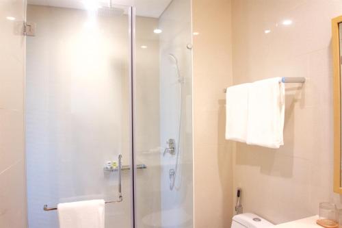 a bathroom with a shower with a glass door at Sunshine Apartment in 5* resort in Da Nang