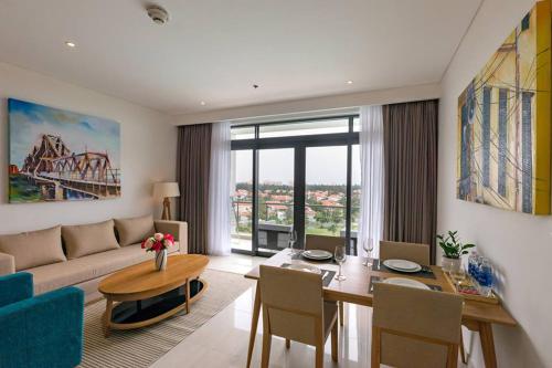 a living room with a couch and a table at Sunshine Apartment in 5* resort in Da Nang