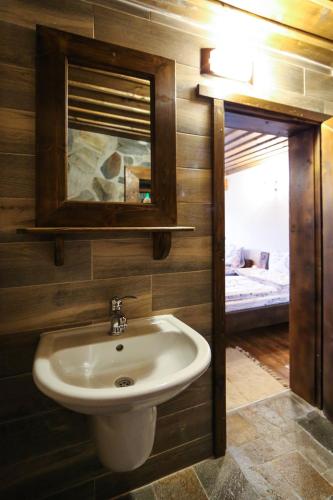 a bathroom with a sink and a mirror and a bed at Yancheva Guest House in Delchevo