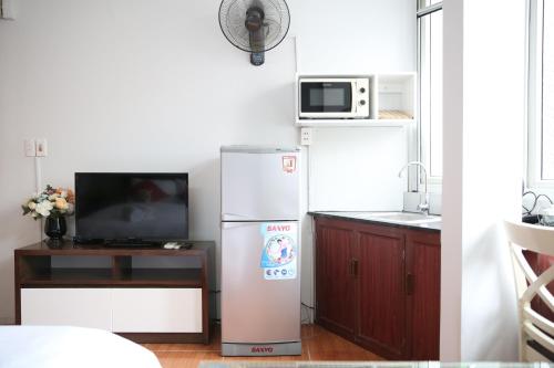 eine Küche mit einem Kühlschrank und einer Mikrowelle in der Unterkunft V-Studio Apartment 2 in Hanoi