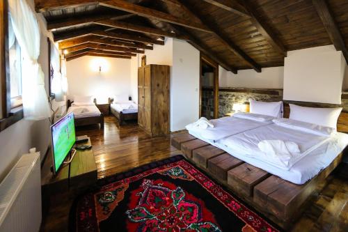 a bedroom with a large bed and a flat screen tv at Yancheva Guest House in Delchevo