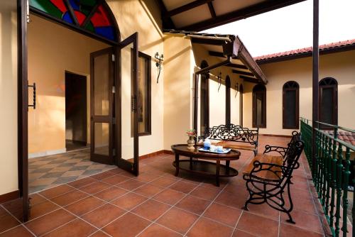 a patio with a table and chairs on a house at The Orchard at Peora Estates in Mukteswar