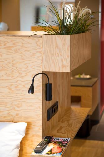 a room with a bed with a plant on a counter at Schlossparkhotel Mariakirchen in Arnstorf