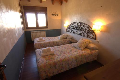 a bedroom with two beds and a window at Casas Rurales Lalo y Chelo in La Aldehuela