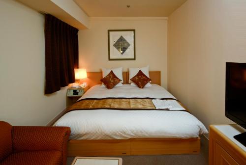 a hotel room with a bed and a television at Hotel The Centre Utsunomiya in Utsunomiya