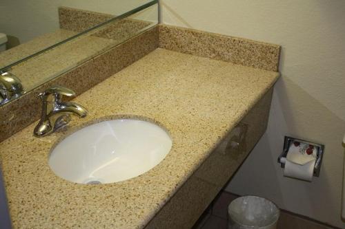a bathroom sink with a granite counter top at Emerald Inn in Maplewood