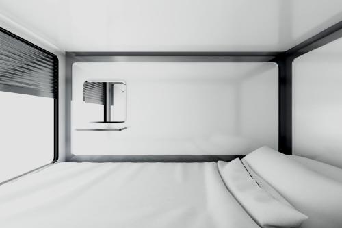 a bed in a room with a window at Qube Capsule Hotel in Moscow