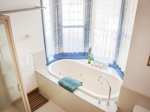 a bath tub in a bathroom with a window at Artee House - A Bright Escape in Bright