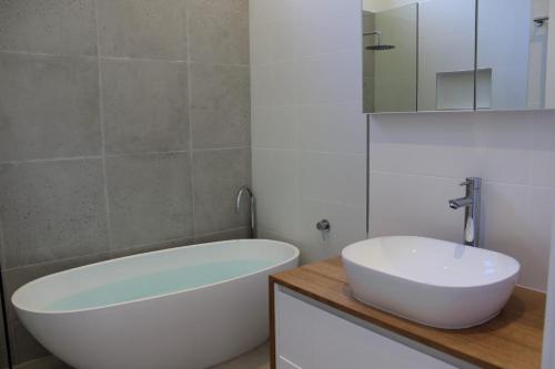 a bathroom with a white tub and a sink at Panorama Views - Bright in Bright