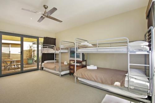 a bedroom with two bunk beds and a patio at Mill House in Bright