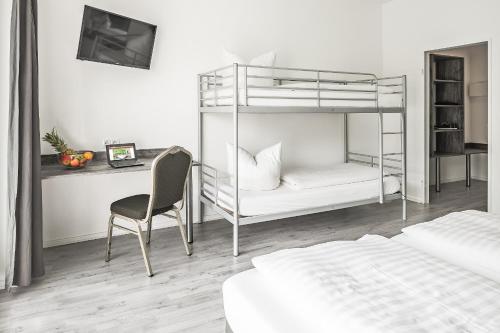 a bedroom with bunk beds and a desk and a chair at Alecsa Hotel am Olympiastadion in Berlin
