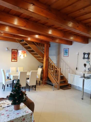 a dining room with a table and chairs and a staircase at Centrum Vendégház in Tihany