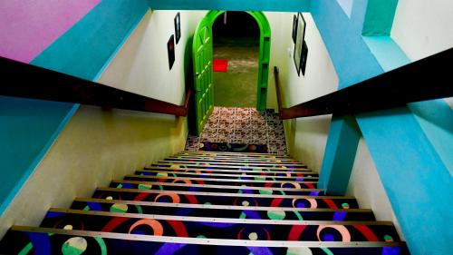 a stairway with a green door and colorful walls at PG Quality Inn in Georgetown