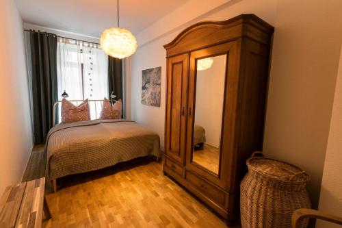 Apartment Waldstraßenviertel في لايبزيغ: غرفة نوم بسرير وخزانة ومرآة
