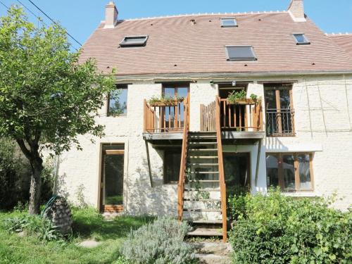a house with a deck on the side of it at La Ferme des Acacias in Ormoy-la-Rivière