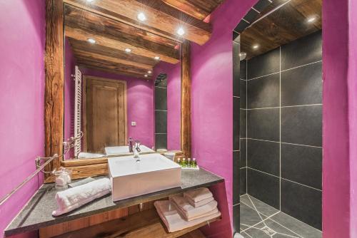 a bathroom with purple walls and a large mirror at Chalet Lièvre Blanc - LES CHALETS COVAREL in Val-d'Isère