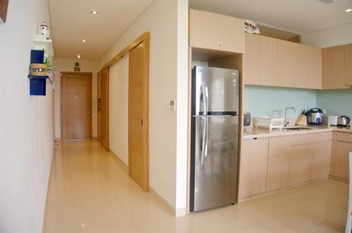 a kitchen with a stainless steel refrigerator in it at Sunshine Apartment in 5* resort in Da Nang