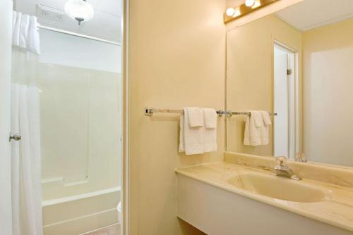 a bathroom with a sink and a shower and a mirror at Knights Inn - Park Villa Motel, Midland in Midland