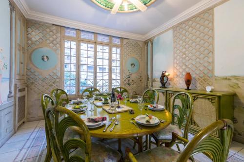 a dining room with a yellow table and chairs at Villa COLLIN - Promenade des Anglais in Nice