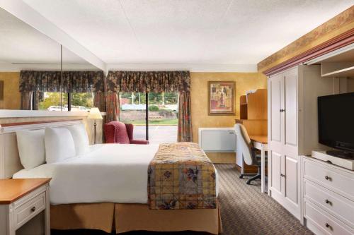 a hotel room with a bed and a television at Travelodge by Wyndham Owen Sound ON in Owen Sound