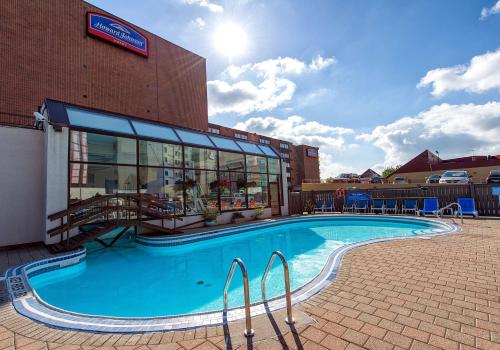 a large swimming pool in front of a building at Howard Johnson Plaza by Wyndham by the Falls Niagara Falls in Niagara Falls