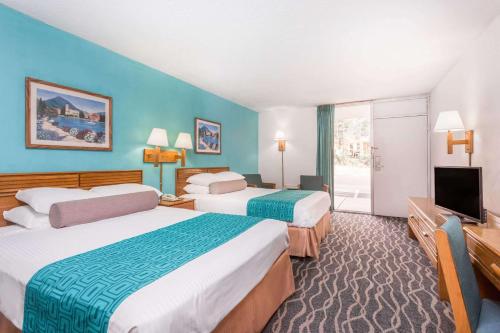 a hotel room with two beds and a flat screen tv at Howard Johnson by Wyndham Commerce GA in Commerce