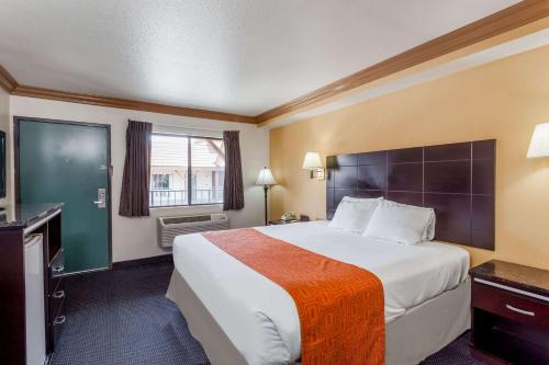um quarto de hotel com uma cama grande e uma janela em Howard Johnson by Wyndham Norco em Norco