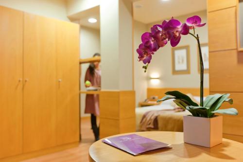 a room with a table with a flower on it at Victoria 4 Puerta del Sol in Madrid