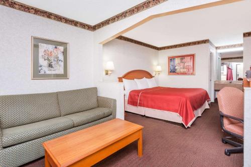 a hotel room with a bed and a couch at Travelodge by Wyndham Chattanooga/Hamilton Place in Chattanooga
