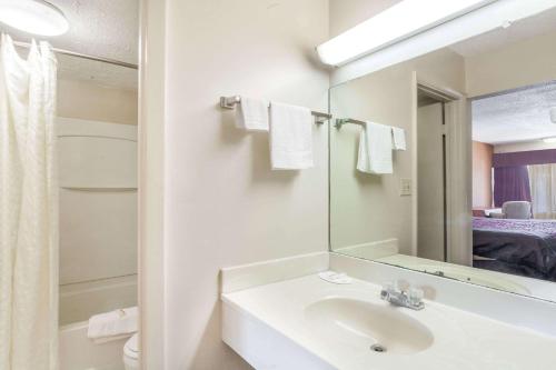 Baño blanco con lavabo y espejo en Knights Inn Murfreesboro, en Murfreesboro