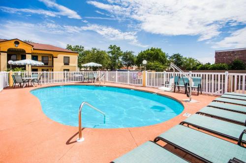 a swimming pool with chairs and a fence at Howard Johnson by Wyndham Panama City in Panama City