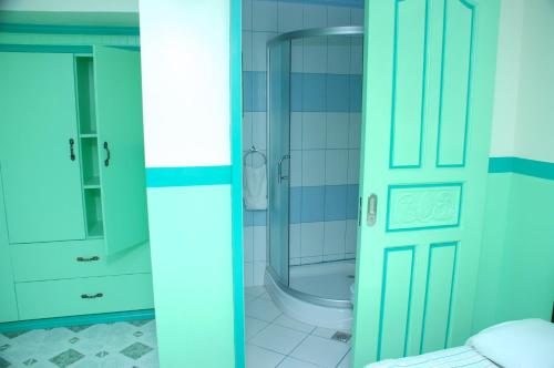 baño con ducha y puerta de cristal en Kokomos Hotel and Restaurant, en Ángeles