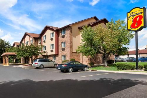 a building with cars parked in a parking lot at Super 8 by Wyndham East Peoria in Peoria