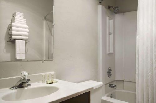 a white bathroom with a sink and a shower at Super 8 by Wyndham Portland Airport in Portland