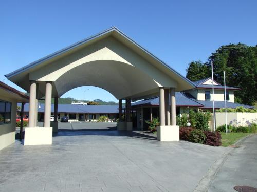 a building with an archway in a parking lot at Belmont Motor Lodge in Porirua