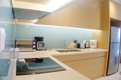 a kitchen with a sink and a refrigerator at Sunshine Apartment in 5* resort in Da Nang
